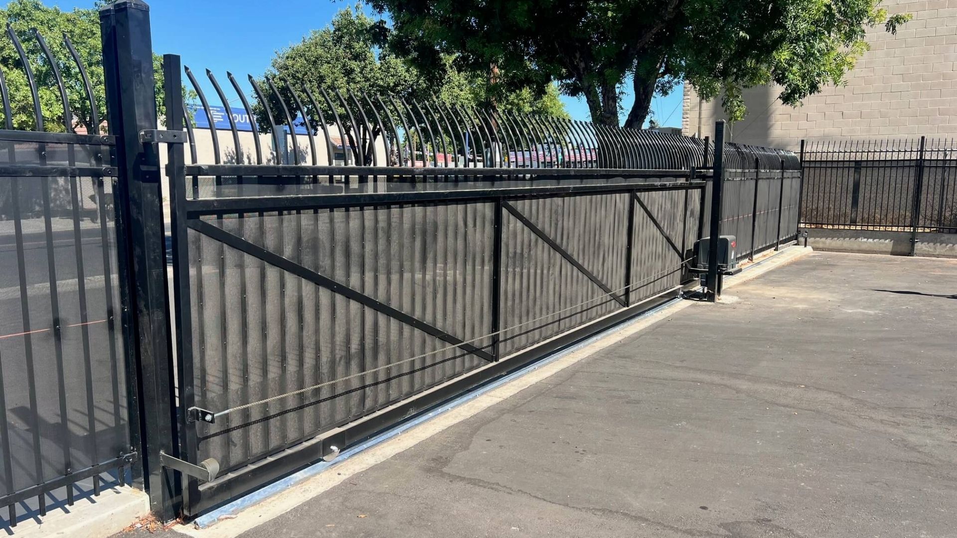 Iron sliding gate with privacy screening and gate operator at Hannah’s House