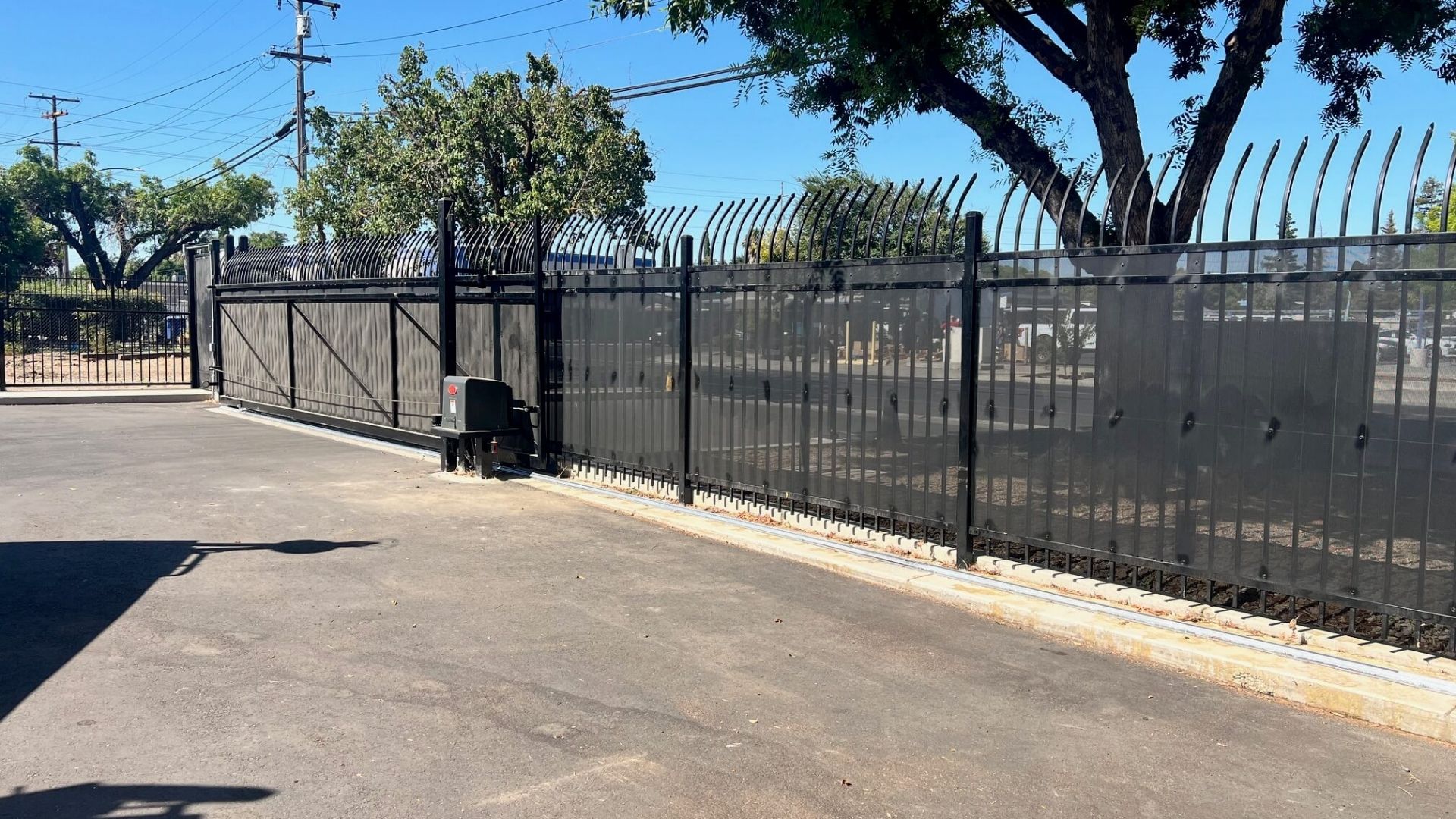 Commercial iron security fencing with privacy screening and automated gate in Modesto