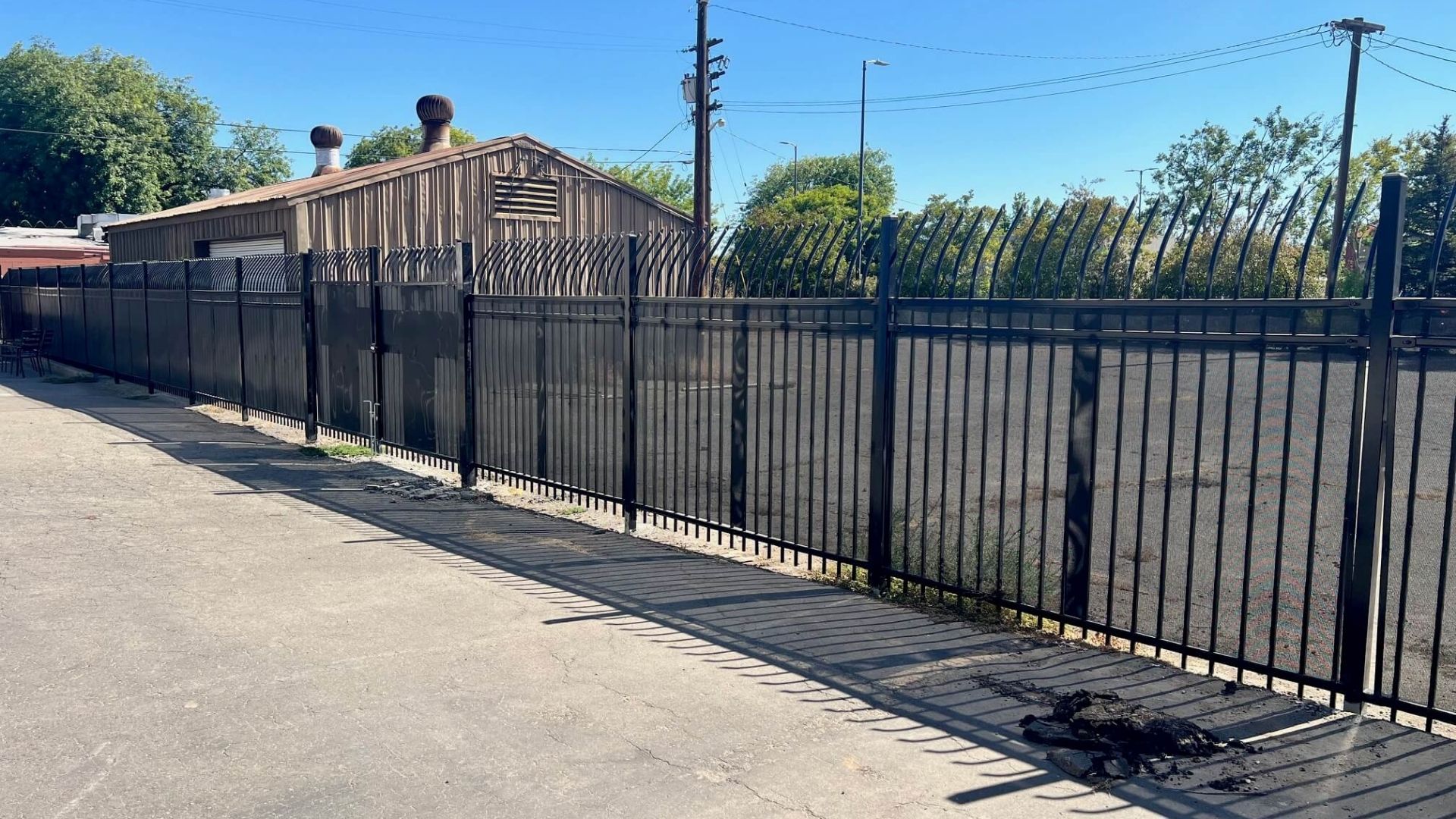 Commercial iron perimeter fence with privacy screening in Modesto