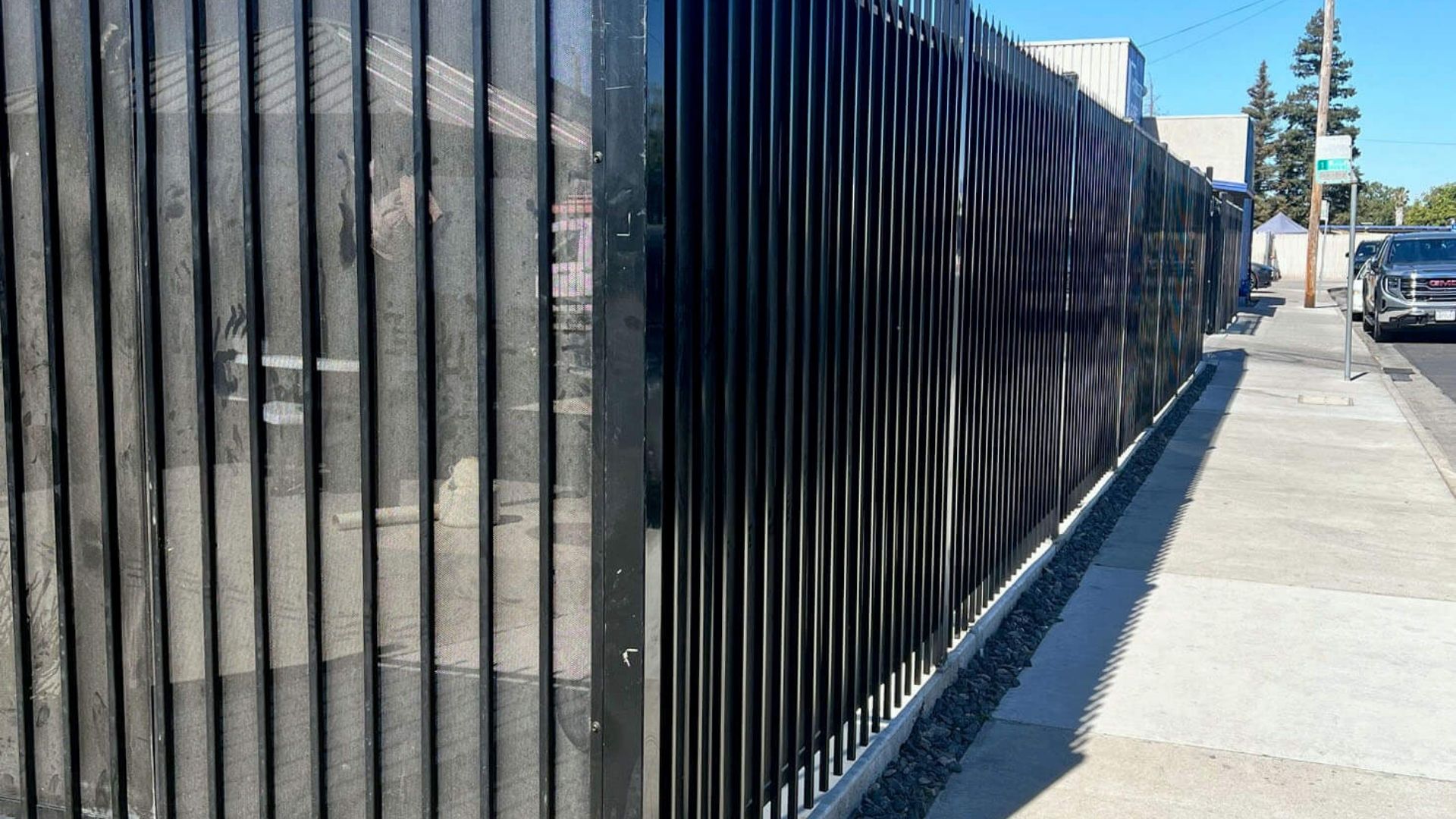 Commercial iron perimeter fence with privacy screening in Modesto, CA